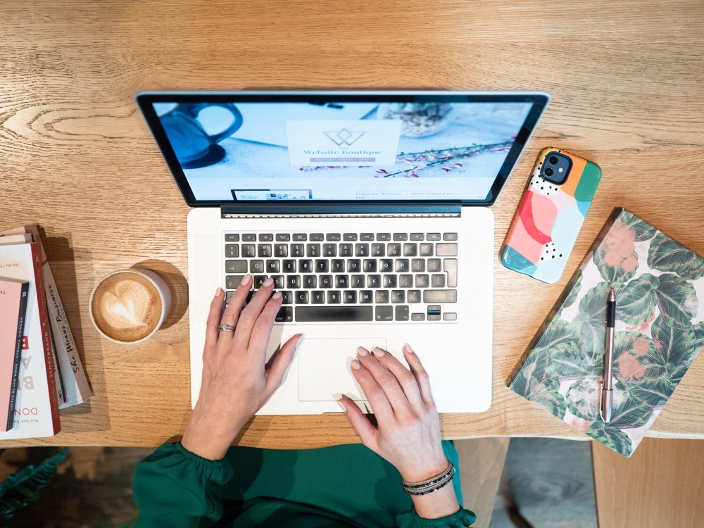 a woman sitting at a desk using a laptop computer.