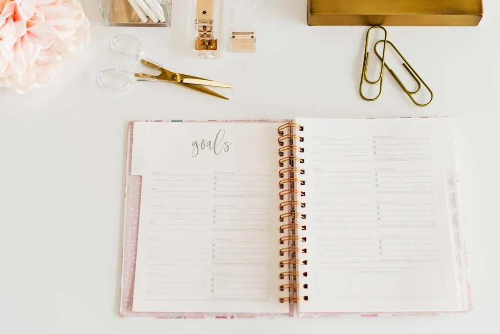 goals diary on white desk with gold accessories