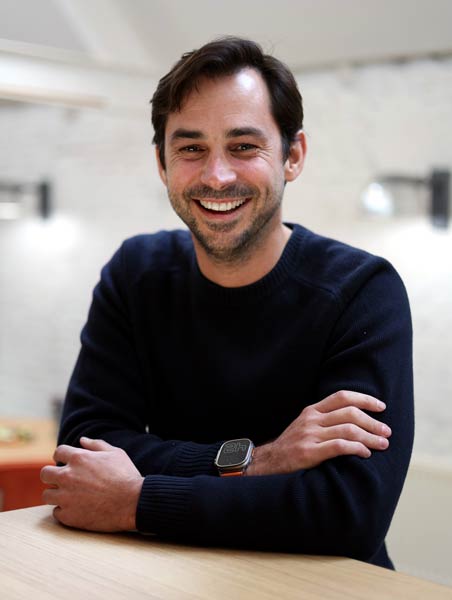 A man happily using a free booking system at a table.