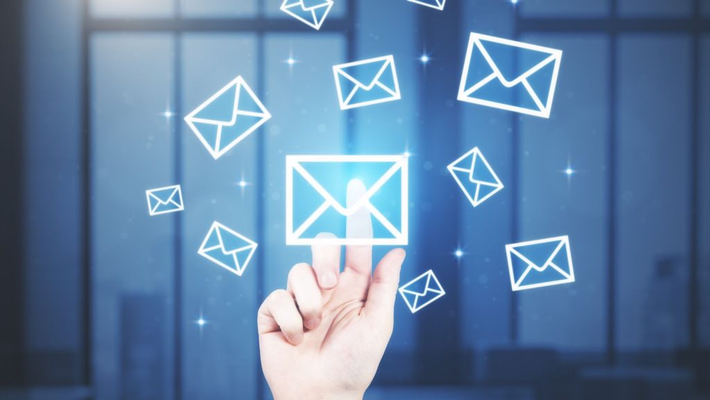 A person's hand is pointing at a bunch of email icons, emphasizing the importance of growing your email list.