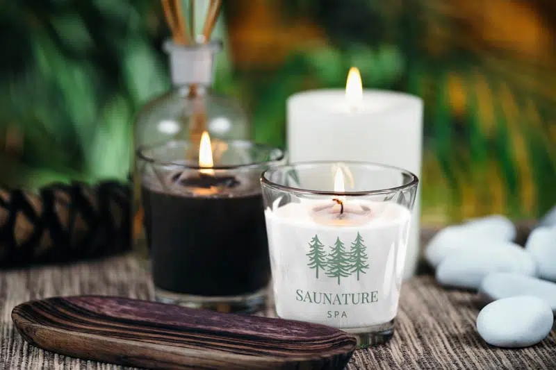 Personalized candles featuring pine trees on a wooden table.